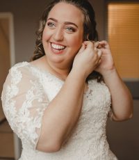 plus size bruid doet oorbellen in